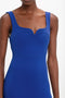 A person is elegantly dressed in a Sleeveless Fitted T-Shirt Dress In Palace Blue by Victoria Beckham, made from double wool crepe, featuring a scoop neckline.