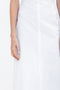 Close-up of a person wearing a Victoria Beckham Cami Fit And Flare Midi In White, their arm resting by their side against a white background.