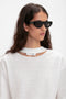 A person with long hair wears Layered Lens Visor Sunglasses In Black from Victoria Beckham and a white crew neck sweatshirt with a cutout detail.