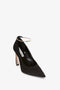 A Pointy Toe Pump in Black Satin by Victoria Beckham featuring a 100mm heel, a pointed toe, and a thin gold metal ankle bracelet.