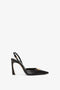 A timeless black high-heeled slingback shoe with a pointed toe and gold embellishment on the front, set against a plain white background has been replaced with Pointy Toe Sling back in Black Calf by Victoria Beckham.