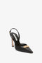 A timeless Victoria Beckham Pointy Toe Slingback in Black Calf with a gold chain detail on the front.