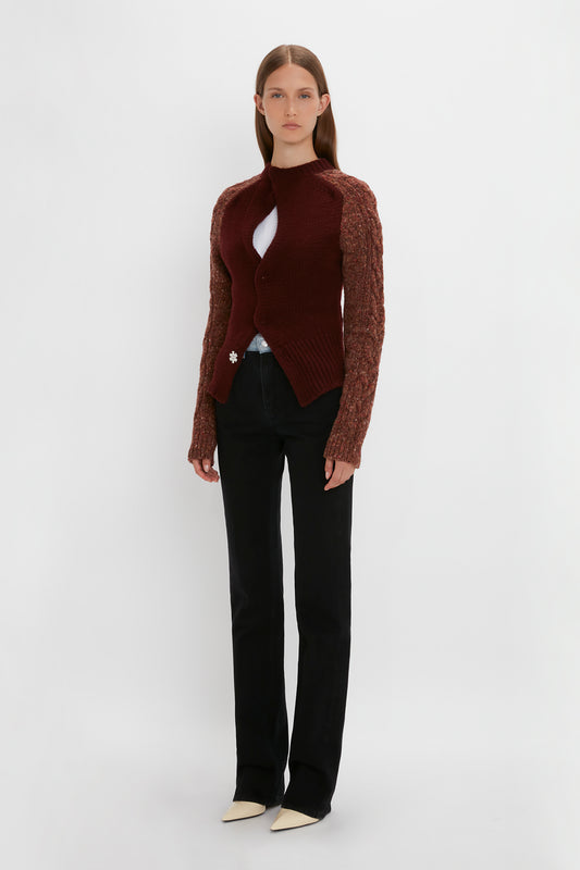 A person stands against a plain background wearing an Exclusive Contrast Sleeve Cardigan In Rust by Victoria Beckham over a white top, black pants, and white shoes.