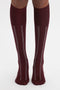 A person wearing Victoria Beckham's Superfine Rib Socks In Burgundy made from 100% cotton.