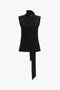 A Victoria Beckham Sleeveless Tie Neck Top In Black featuring a high neck with an attached luxurious double neck tie draped in front.