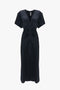 A navy Exclusive Gathered V-Neck Midi Dress In Navy with a knee-length hemline and short sleeves. The figure-flattering stretch fabric features a gathered detail at the waist and subtle stitching along the shoulders, by Victoria Beckham.