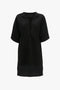 A Frame Cut-Out T-Shirt Dress In Black by Victoria Beckham in bonded linen jersey with a V-shaped neckline and a loose, flowing fit.