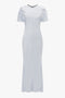 A long, white, short-sleeve, Gathered Sleeve Midi Dress In Ice by Victoria Beckham with a fitted silhouette and a round neckline goes perfectly with flat lace up mules.