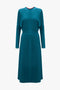 Long-sleeved, teal knee-length Long Sleeve Dolman Midi Dress In Petroleum by Victoria Beckham with a high, round neckline and subtle seam detailing on the front. This dress boasts contemporary sophistication with its clean, minimalist design and fluid cady fabric.