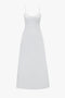 A long, white summer dress with thin adjustable spaghetti straps and a fitted bodice. The Cami Fit And Flare Midi In White by Victoria Beckham, made from breathable stretch cotton, features a flowing, floor-length skirt that exudes effortless elegance.