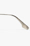 A close-up image of a Victoria Beckham V Metal Pilot Sunglasses In Silver-Brown with a curved handle, featuring a Victoria Beckham logo, isolated on a white background.