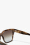 Close-up of a pair of Victoria Beckham Soft Square Frame Sunglasses In Striped Khaki Havana with the interior side of the arm displaying small text, including "Made in Italy" and other details.