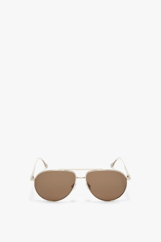 A pair of Victoria Beckham V Metal Pilot Sunglasses In Gold-Khaki with brown lenses, complete with thin gold frames and adjustable nose pads, positioned against a plain white background.