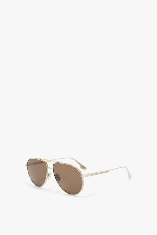 A sleek pair of V Metal Pilot Sunglasses In Gold-Khaki, featuring adjustable nose pads for a comfortable fit, and subtly adorned with the Victoria Beckham logo, all against a plain white background.