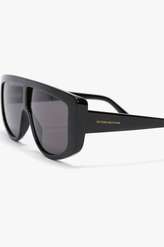 Acetate Visor Sunglasses In Black with black tonal lenses and the text "Victoria Beckham" on the left temple, embodying the chic elegance of Victoria Beckham eyewear.