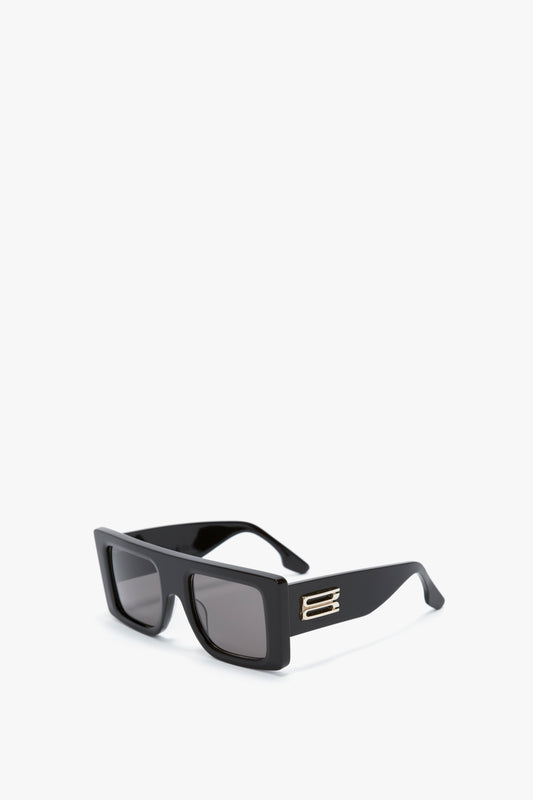 A pair of rectangular black **Oversized Frame Sunglasses In Black** with dark lenses and a small metallic detail on the arms, featuring the brand's signature B frame buckle, displayed against a white background by **Victoria Beckham**.