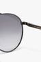 Close-up of a pair of Victoria's favorite V Metal Pilot Sunglasses In Grey Gradient with dark lenses and a gunmetal grey gradient, featuring the brand name "Victoria Beckham" written on the arm.