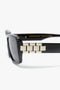 Close-up of Victoria Beckham eyewear, showcasing Victoria Beckham Chain Detail Rectangular Frame Sunglasses In Black with a woven gold-tone detail on the temple, elegantly combining acetate and metal.