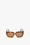 Victoria Beckham V Plaque Rectangular Frame Sunglasses In Tortoise, positioned upright against a plain white background.