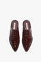 A pair of Victoria Beckham Flat Lace Up Mules In Bordeaux Leather with brogue details, pointed toes, and slip-on construction on a plain white background.