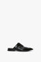 A black leather mule shoe with lace-up design and Oxford brogue detailing, featuring slip-on construction, displayed on a white background. This is the Flat Lace Up Mules In Black Leather by Victoria Beckham.