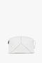 A small, white calf leather clutch with a structured design, featuring minimal stitching and a side zipper is the Exclusive Victoria Clutch Bag In White Leather by Victoria Beckham.