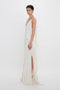 A woman in a Victoria Beckham Exclusive Asymmetric Bias Frill Dress In Ivory gown posing against a white background.