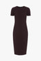 A knee-length, short-sleeve, Fitted T-Shirt Dress In Deep Mahogany by Victoria Beckham with a round neckline, reminiscent of Victoria Beckham's sophisticated style.