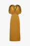 A V-Neck Ruffle Midi Dress In Harvest Gold by Victoria Beckham featuring ruched short sleeves, an elastic waistband, and a seductive knee-length hem.