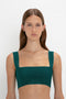 A person with long hair wears a VB Body Strap Bandeau Top In Lurex Green and a VB Body Flared Skirt against a plain white background.