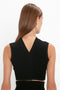 A person with long brown hair, wearing a versatile VB Body Scallop Trim Tank Top In Black by Victoria Beckham featuring a V-shaped neckline, is shown from the back against a plain white background—truly a summer essential.