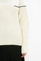 A close-up of a person wearing a Collar Detail Jumper In Natural by Victoria Beckham, paired with a black skirt.