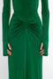 A person in a Circle Detail Open Back Gown In Emerald by Victoria Beckham, with a gathered design at the waist and shoulder pads, positioned against a plain white background.