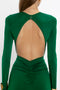 A person wearing the Circle Detail Open Back Gown In Emerald by Victoria Beckham, featuring a large open back and ruched detailing at the lower back, resembling an elegant exposed back gown.