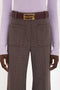 Person wearing a light purple sweater, Victoria Beckham Alina Trouser In Tobacco with a maroon belt featuring a gold buckle. The image is cropped to show only the torso and upper legs.