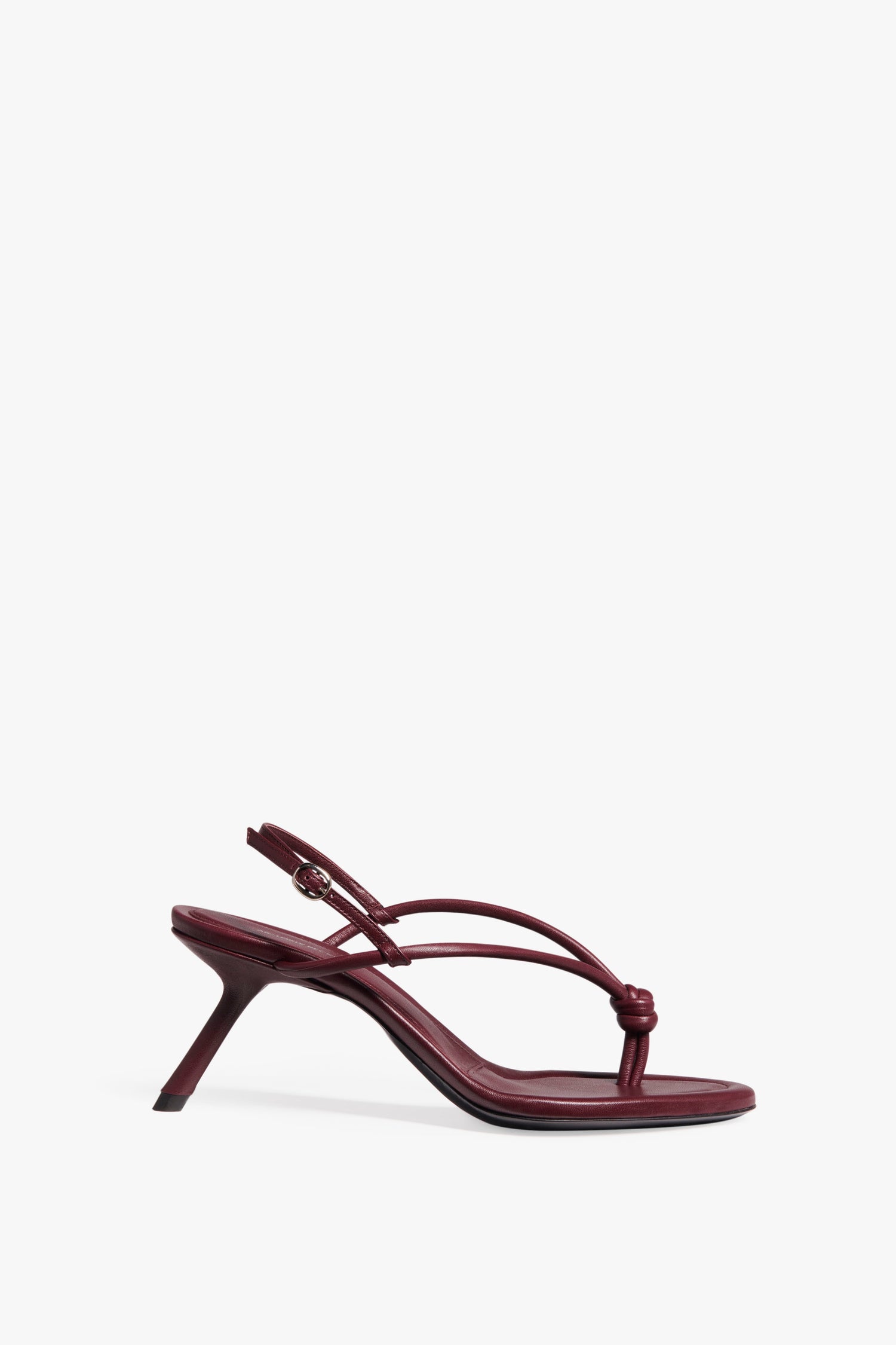 A single Estelle in Bordeaux high-heeled sandal crafted from Bordeaux nappa leather by Victoria Beckham, featuring a knotted toe post on top and an ankle strap with a small buckle, set against a white background.