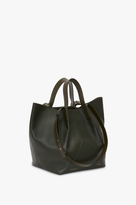 A Victoria Beckham W11 Jumbo Tote In Loden Leather in dark green with double handles and a detachable shoulder strap, boasting an elegant V-shaped design, set against a plain white background.