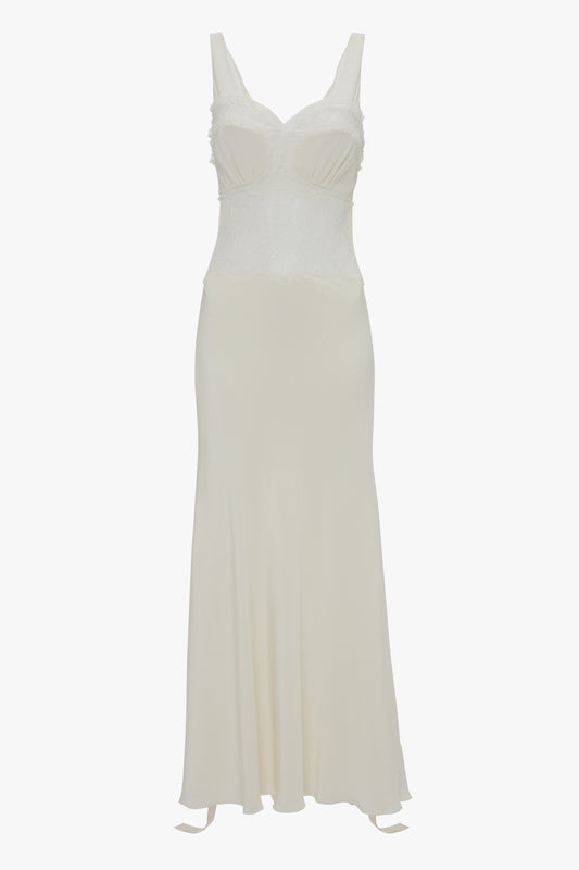 A long, white sleeveless midi dress with a fitted bodice and flowing skirt. The Ruffle Detail Midi Dress In Ivory by Victoria Beckham features lace panels around the bust and midsection.
