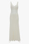 A long, white sleeveless midi dress with a fitted bodice and flowing skirt. The Ruffle Detail Midi Dress In Ivory by Victoria Beckham features lace panels around the bust and midsection.