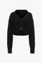 Black Victoria Beckham cropped v-neck cardigan with a ribbed knit texture and front button closure, displayed on a plain white background.