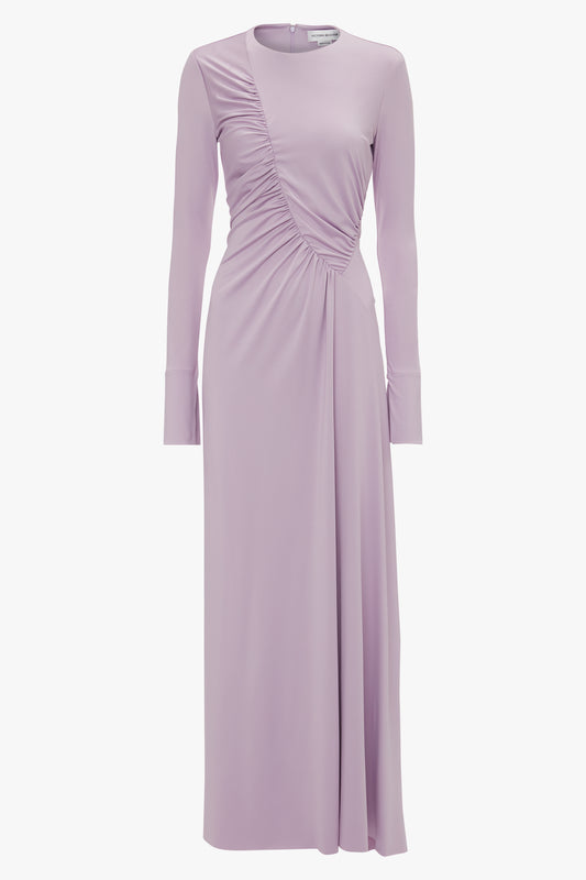 A long-sleeved, lavender dress in stretch jersey with asymmetrical ruching on the front, featuring a round neckline and a fitted silhouette: the Ruched Detail Floor-Length Gown In Petunia by Victoria Beckham.