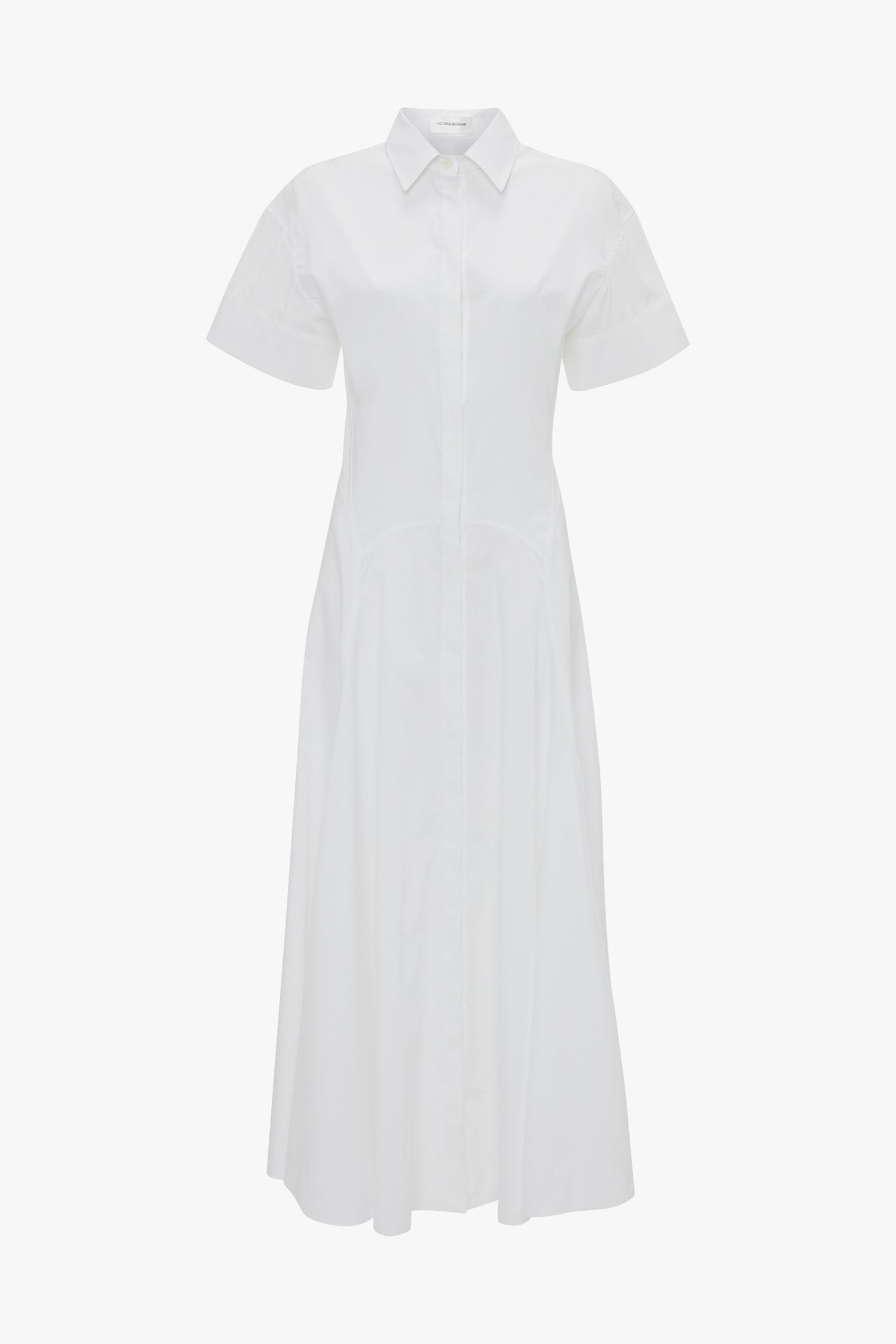 The Panelled Shirt Dress In White by Victoria Beckham is crafted from organic cotton poplin, featuring a button-down front, gold button cuffs, and a flared skirt.