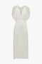 Exclusive V-Neck Ruffle Midi Dress In Ivory with cap sleeves featuring delicate ruffle details and a slightly gathered waist, reminiscent of Victoria Beckham's sophisticated style.