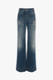 A pair of tailored blue wide-leg jeans with front and back pockets, featuring slight fading and a high waist, resembling the Alina High Waisted Jean In Heavy Vintage Indigo Wash by Victoria Beckham.