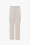 A pair of beige, military-inspired cargo trousers with a relaxed silhouette, multiple pockets, and belt loops, crafted from 100% cotton, displayed against a plain white background has been replaced with "Victoria Beckham's Relaxed Cargo Trouser In Bone.