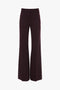 Back view of the Victoria Beckham Alina Trouser In Deep Mahogany, made from recycled wool, featuring two back pockets and belt loops.