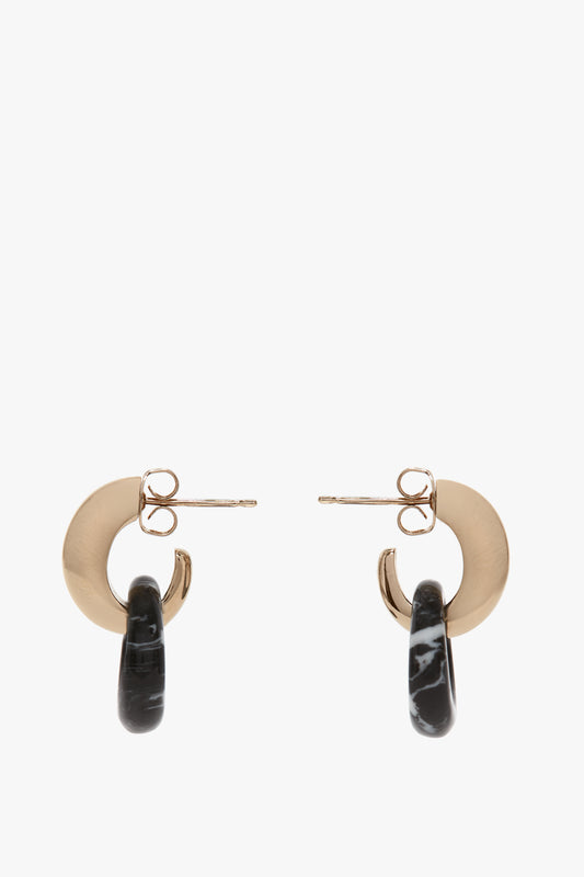 A pair of Exclusive Resin Pendant Earrings In Light Gold-Black by Victoria Beckham with gold circular studs and black looped marble accents, crafted from 100% brass.
