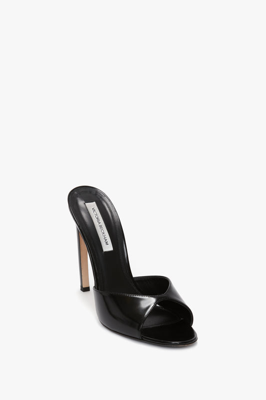 Classic Mule In Black Calf Leather with a seductive curved heel and a glossy finish, crafted from luxury calf leather, featuring a Victoria Beckham tag on the insole, set against a white background.