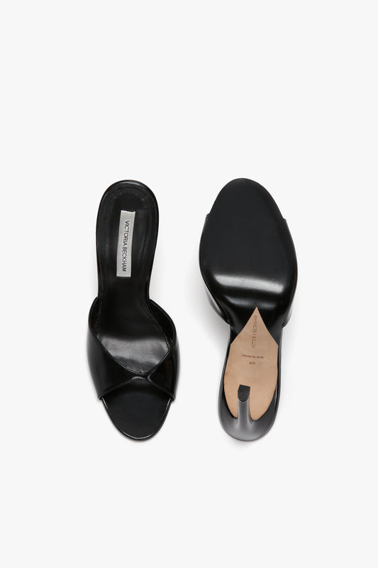 A pair of Victoria Beckham Classic Mule In Black Calf Leather shoes, one shown top-down and the other displaying the seductive curved heel.