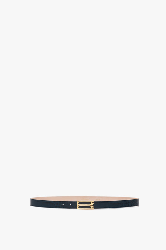 A Victoria Beckham Frame Belt In Midnight Blue Croc Embossed Calf Leather with gold hardware and a rectangular buckle is displayed against a white background.